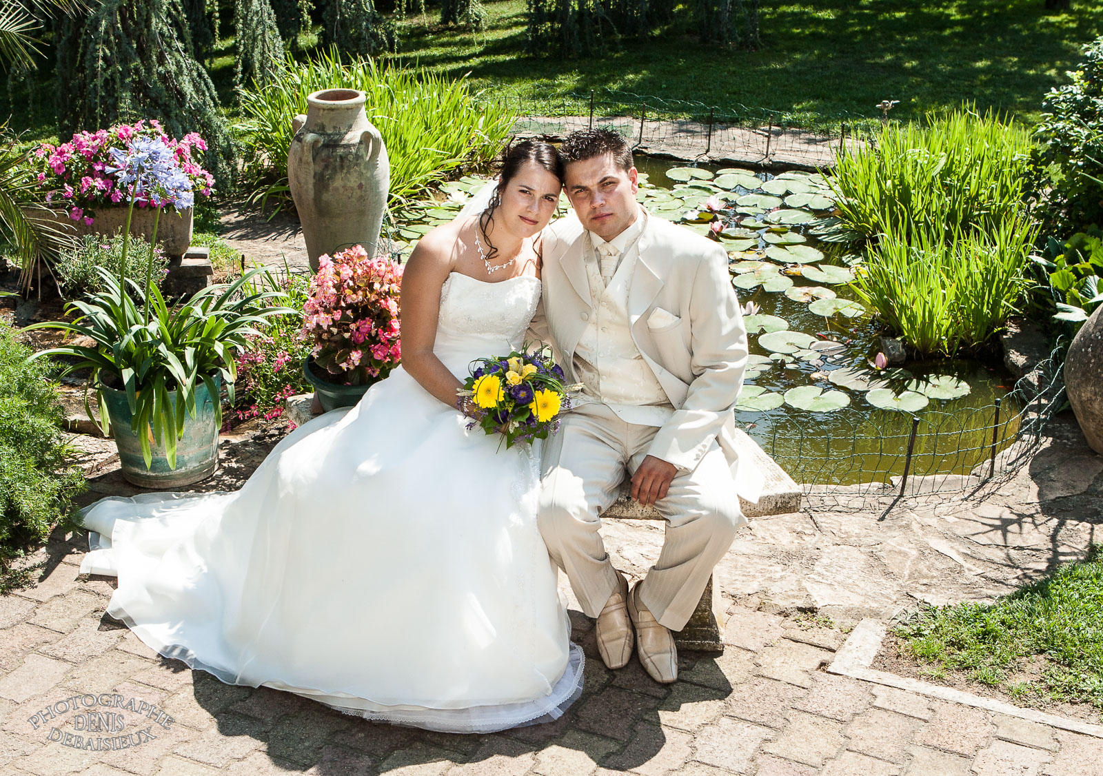 La mariée et le marié assis sur un ban
