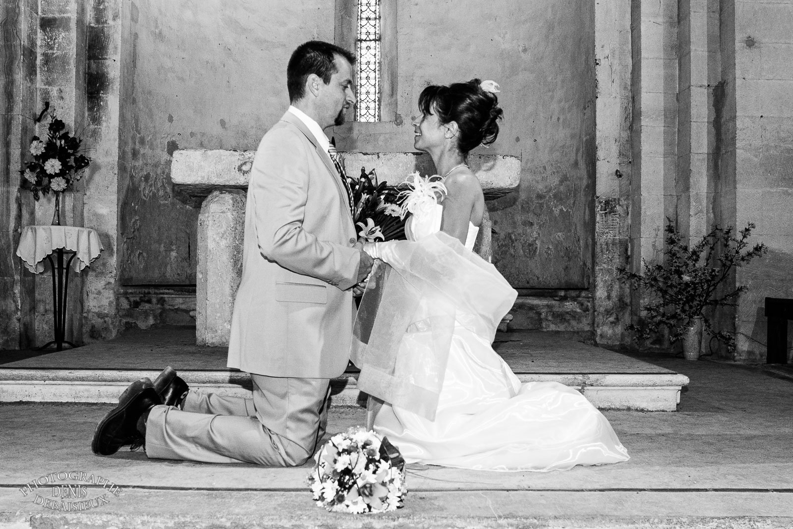 Mariée et marié à genou à l'église
